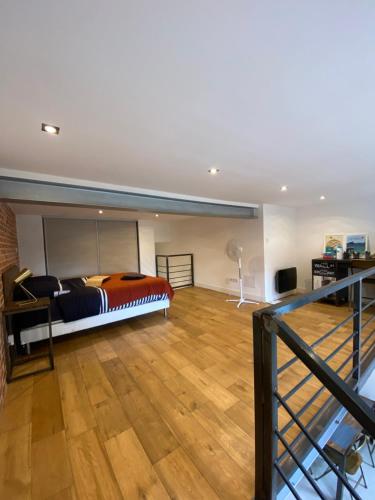 une chambre avec un lit et un parquet dans l'établissement Charmant Loft Moderne à 10min de la Grande Plage, à Biarritz
