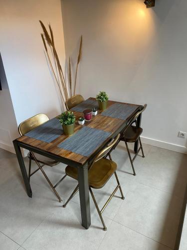 d'une table en bois avec des chaises et des plantes. dans l'établissement Charmant Loft Moderne à 10min de la Grande Plage, à Biarritz