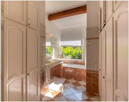 La salle de bains est pourvue d'un lavabo, d'une baignoire et d'une fenêtre. dans l'établissement Villa Mare e Monti, à Coti-Chiavari