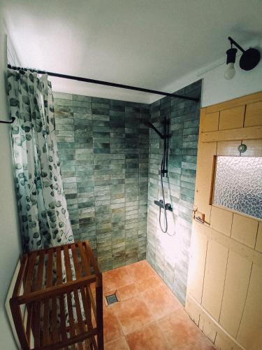 a bathroom with a shower with a bench in it at Montijo Garden - Studio with garden view in Montijo