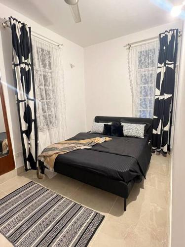 Un dormitorio con una cama en una habitación con ventanas. en Classy 1bhk near brigade,mg road, en Bangalore