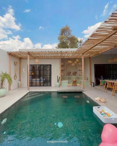 a swimming pool in front of a house at Bohemian Private pool Villa - Fulton Casablanca in Beran-kidul