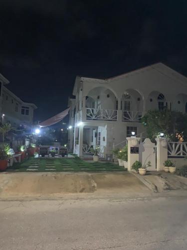 a large white house at night at Sea Shells Villa in Christ Church