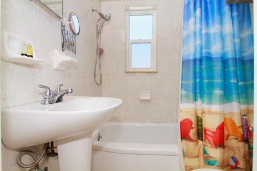 un bagno con lavandino e tenda da doccia di Tropic Terrace Suite #45 - Beachfront Resort a St Pete Beach