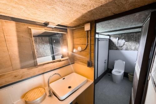 a small bathroom with a sink and a toilet at Chiewlan Camp and Resort in Ban Pha Saeng Lang