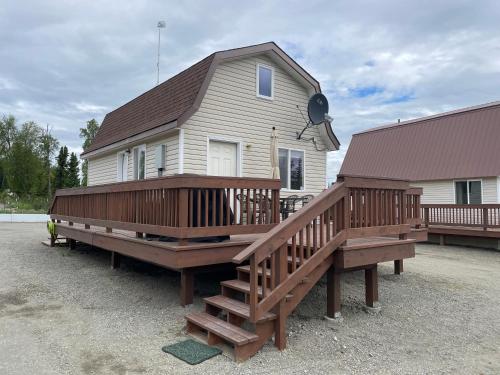 une maison avec une grande terrasse et une maison dans l'établissement Peaceful Acres Cabin 3 - Soldotna, AK, à Kasilof