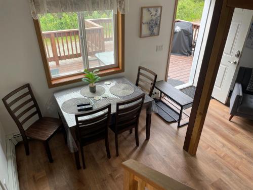une salle à manger avec une table et des chaises ainsi qu'une terrasse couverte dans l'établissement Peaceful Acres Cabin 3 - Soldotna, AK, à Kasilof