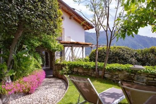 a garden of a house with chairs and flowers at Il Monsignore - Finnish WoodenJacuzzi and Stunning Lake Views in Cernobbio