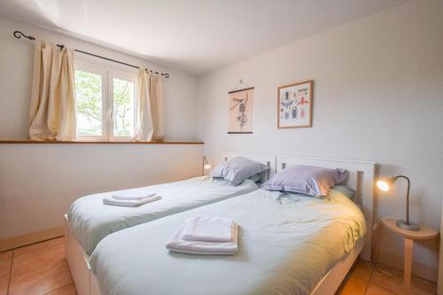 a bedroom with two beds with towels on them at Domaine d'Essendiéras in Saint-Médard-dʼExcideuil