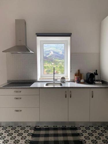 a kitchen with a sink and a window at Lugar da Borralheira in Verdelhos