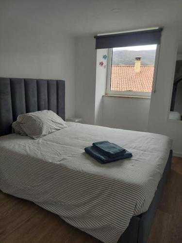a bed with a blue bag sitting on top of it at Lugar da Borralheira in Verdelhos