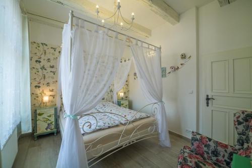 a bedroom with a canopy bed with curtains at Penzion U Zámku in Mělník