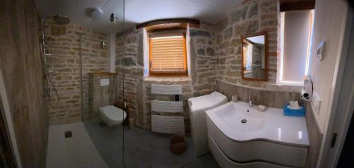 a bathroom with a sink and a tub and a toilet at La ferme des Soudanières in Ceyzériat