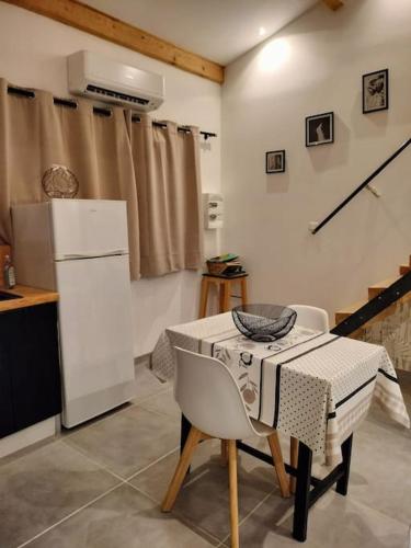 a kitchen with a table and chairs in a room at Havre de paix ressourçant in Mallemoisson