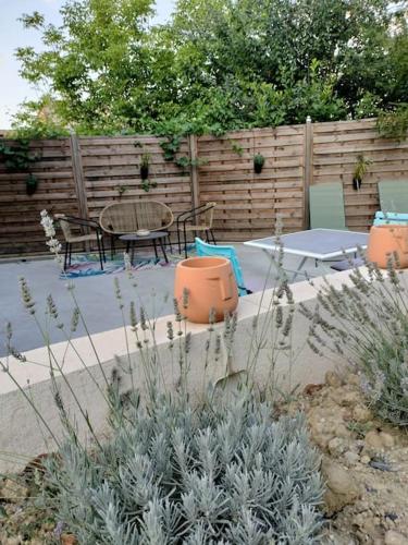 a patio with a table and chairs and a fence at Havre de paix ressourçant in Mallemoisson