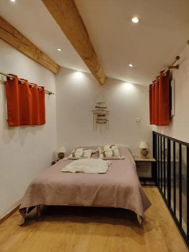 a bedroom with a large bed with red curtains at Havre de paix ressourçant in Mallemoisson