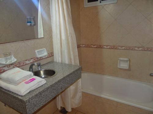 a bathroom with a sink and a bath tub at HSJ Balcarce in Balcarce