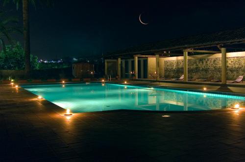 a swimming pool at night with a moon in the sky at Etna Hotel in Giarre