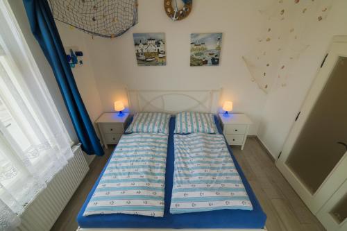 a blue bed in a room with two lamps at Penzion U Zámku in Mělník