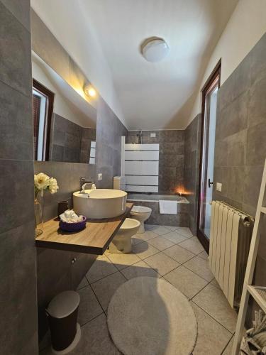 a bathroom with two toilets and a tub and a sink at Sveva Haven Malpensa in Case Nuove