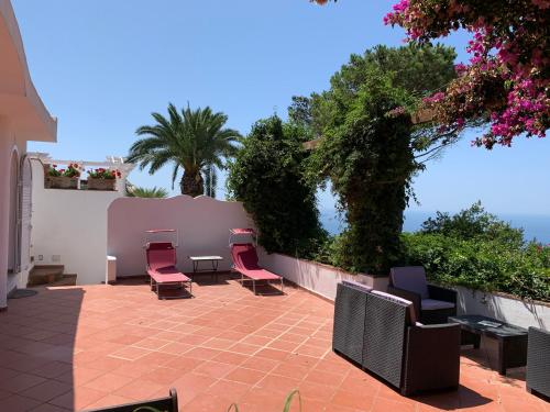 a patio with chairs and a table and a fence at Casa Blu in Anacapri