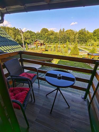 a patio with two chairs and a table on a balcony at Pensiunea Pastravaria Vistisoara in Vistisoara
