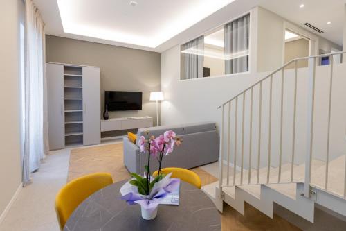 a living room with a table with flowers on it at Teatro Romano Exclusive Suites in Trieste
