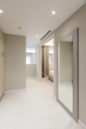 an empty room with a mirror and a bed at Teatro Romano Exclusive Suites in Trieste