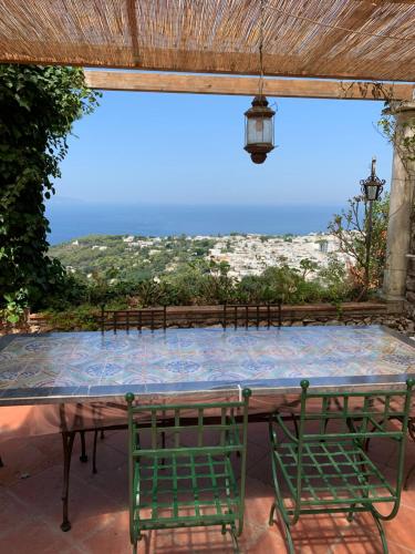 a table with chairs and a view of the ocean at Casa Blu in Anacapri