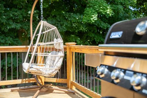a bird cage hanging on a deck next to a grill at Norwalk Retreat in Norwalk