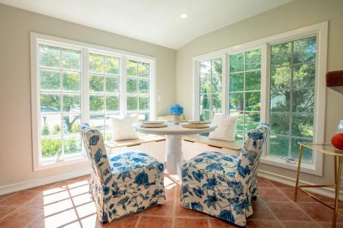 a dining room with a table and chairs and windows at Norwalk Retreat in Norwalk
