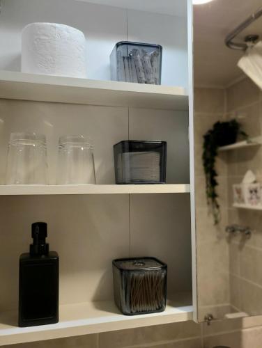a bathroom shelf with glasses and other items on it at Apartment mit Balkon am Rhein in Koblenz