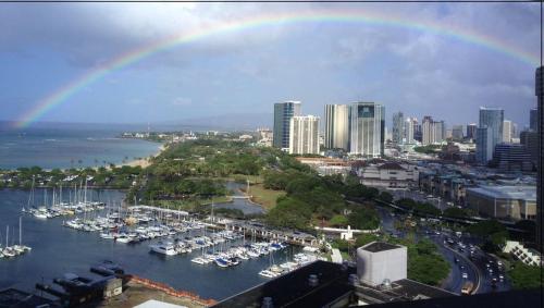 a rainbow over a harbor with boats in the water at Waikiki Studio Steps to Beach-Mall Free Parking-WiFi in Honolulu