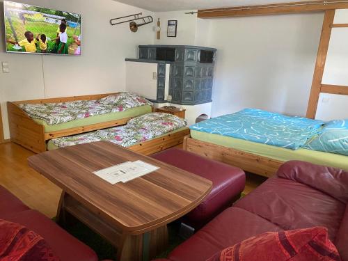 Habitación con 3 literas y mesa. en Ferienzimmer Oelhaf Zimmer mit Couch Self Check-In mit Key-Tresore, en Wilhelmsdorf