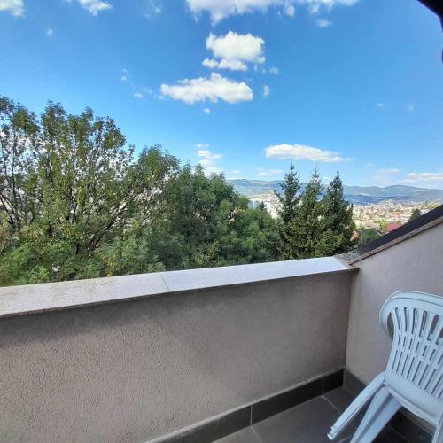 a white chair sitting on a balcony with a view at Villa Sabic in Sarajevo