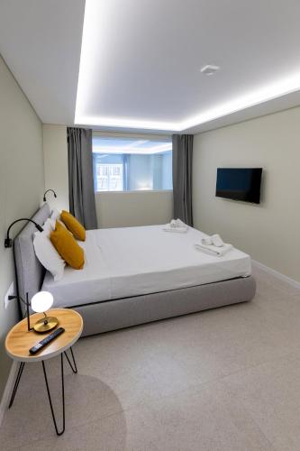 a bedroom with a large bed and a table at Teatro Romano Exclusive Suites in Trieste