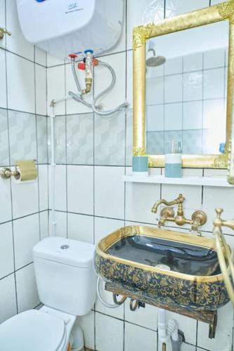 a bathroom with a white toilet and a sink at NINJA HOUSE Studio chic Le Turquois Doré in Yaoundé