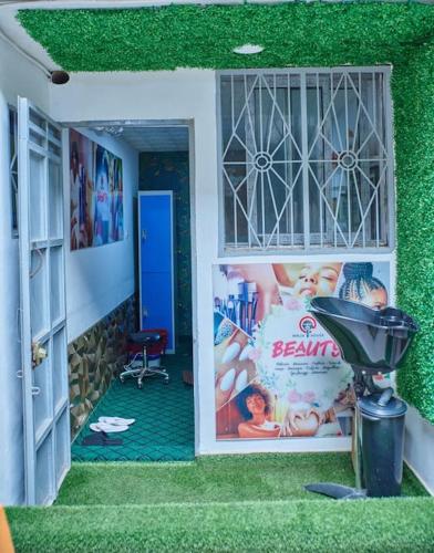 a room with green grass and a door with a lamp at NINJA HOUSE Studio chic Le Turquois Doré in Yaoundé