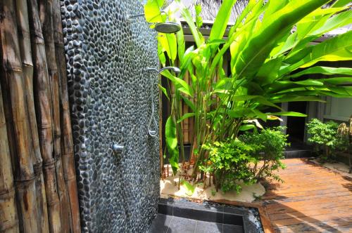 a shower in a garden with plants at Octopus Resort in Nalauwaki
