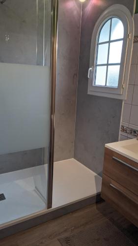 une douche avec une porte vitrée dans une salle de bain dans l'établissement Gîte LA BRUGUE avec piscine à 5 mn d'ALBI, à Puygouzon-et-Montsalvy