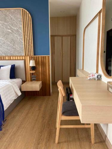 a bedroom with a bed and a desk with a table at เดอะซีน คาบาน่า บีช รีสอร์ท ขนอม The Scene Cabana Beach Resort Khanom in Ban Plau