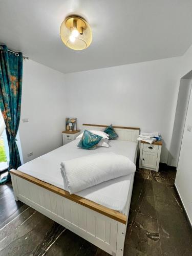 a bedroom with a white bed with a light on it at Casa Ilinca in Dărmăneşti