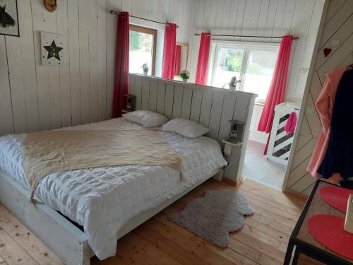 a bedroom with a large bed with red curtains at La petite suisse in Malmedy