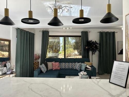 a living room with a blue couch and green curtains at Luxury Kouklia Maisonette in Paphos