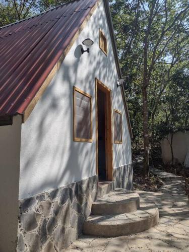 ヒリトゥラにあるCabaña Calandriaの白い小さな建物(ドア、階段付)