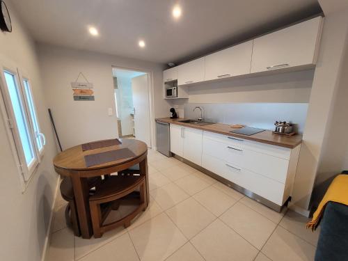 une cuisine avec une table en bois et une petite table dans l'établissement Studio cosy proche lac et centre ville, à Soustons