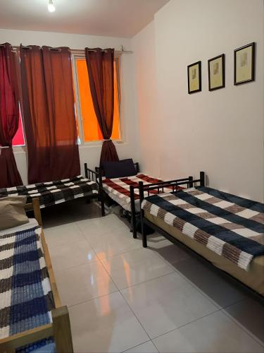 a room with two beds and a window at Corniche Street - For Males "Peaceful Bed Space" in Abu Dhabi