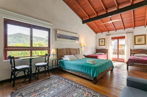a bedroom with a bed and a table and chairs at Pousada Casa da Lagoa in Florianópolis