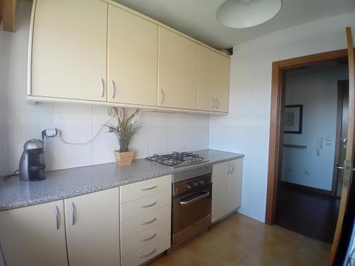 a kitchen with white cabinets and a stove at Lisbon Blue - Metro at your Door in Lisbon