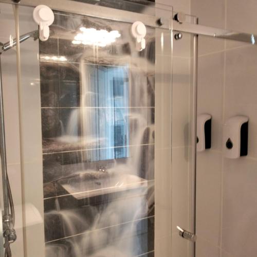 a shower with a glass door with a sink at Wind House in Costa de Antigua